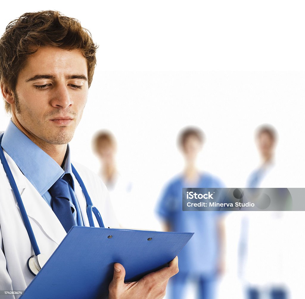 Doctor portrait Portrait of a doctor reading a case history in front of his team Adult Stock Photo