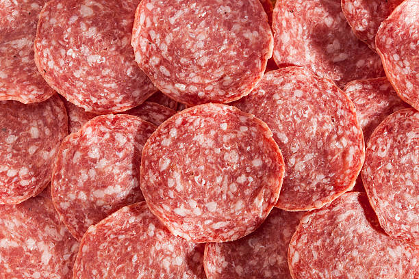 Fresh Cut Organic Salami Fresh Cut Organic Salami against a background salami stock pictures, royalty-free photos & images