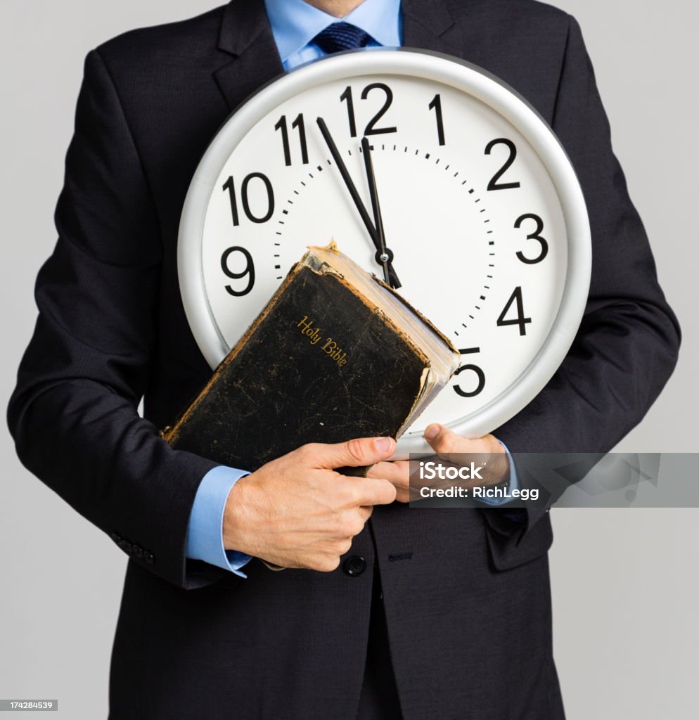 男性の保持クロックおよび聖書 - 時計のロイヤリティ��フリーストックフォト