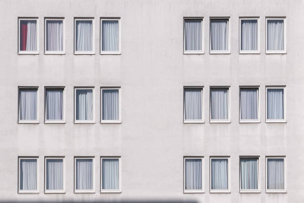 istock pattern of a white house wall with windows in geometrical order as symbol for apartment building 1742848191
