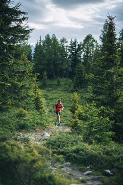 Trail runner bounds along mountain trail