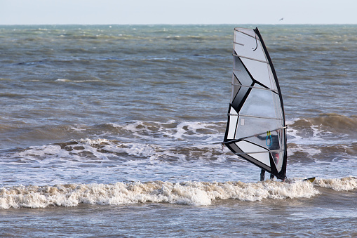 Erquy, Brittany, France, August 27, 2023 - A young athlete on a wing foil board in the harbor area of Erquy, Brittany.