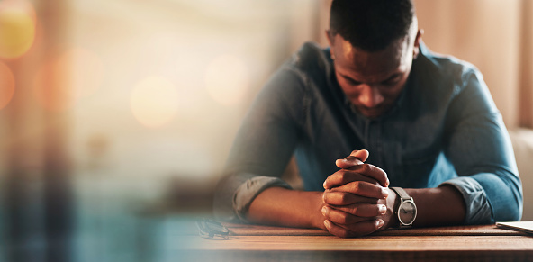 Black man, hands and praying with worship and banner,  God and religion, faith with guidance and gratitude. Respect, spiritual and prayer with belief, blessing and mockup space with bokeh and trust