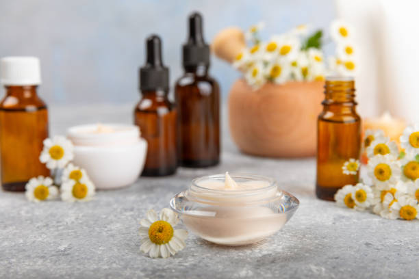 istock Chamomile spa. Composition with chamomile flowers, handmade soap, essential oil cosmetic bottle, body cream, scrub and sea salt on a white texture background. Relaxing beauty treatments.Copy space 1742894395
