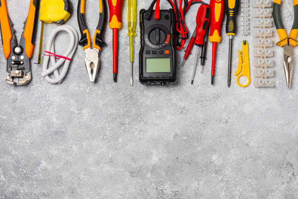 istock Electrician tools on background.Multimeter,construction tape,electrical tape, screwdrivers,pliers,an automatic insulation stripper, socket and LED lamp.Flatley.electrician concept. 1742896573