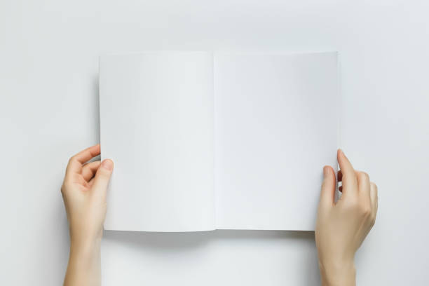 istock woman holding open book with blank white pages on white table 1742934554