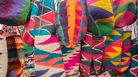 Otavalo, Imbabura / Ecuador - October 14 2023: Close-up of Shigras hanging for sale in the Plaza de los Ponchos in the city of Otavalo. Shigra is a hand-woven indigenous bag.