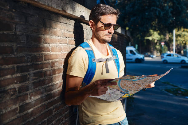 istock Young male tourist reading a map while exploring big city 1742991169