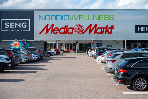 Gothenburg, Sweden - July 27 2023: Large parking lot outside a mall with Nordic Wellness and Media Markt.