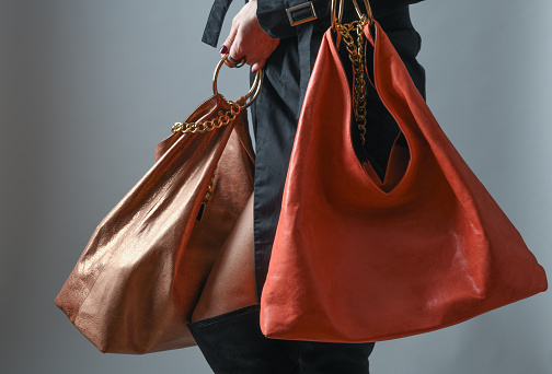 Bright leather handbag hangs on a woman's hand