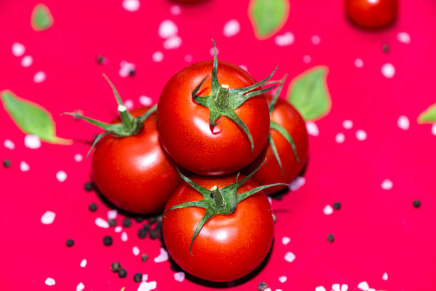 istock Fresh, red cherry tomatoes with green stems on red bckground 1743056669
