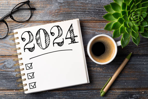 istock New year resolutions 2024 on desk. 2024 resolutions list with notebook, coffee cup on table. Goals, resolutions, plan, action, checklist concept. New Year 2024 template 1743067264