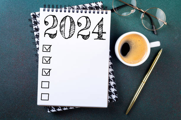 istock New year resolutions 2024 on desk. 2024 resolutions list with notebook, coffee cup on table. Goals, resolutions, plan, action, checklist concept. New Year 2024 template 1743067283
