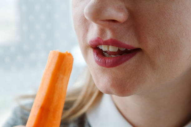 istock Young woman bites raw carrot, 1743084881