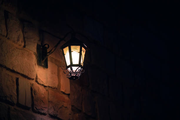Old street lamp on a stone wall. Night stock photo