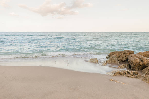 2023년 가을 해질녘 플로리다주 팜비치 바위 해안선 너머의 파스텔 일몰 하늘 - southern usa sand textured photography 뉴스 사진 이미지