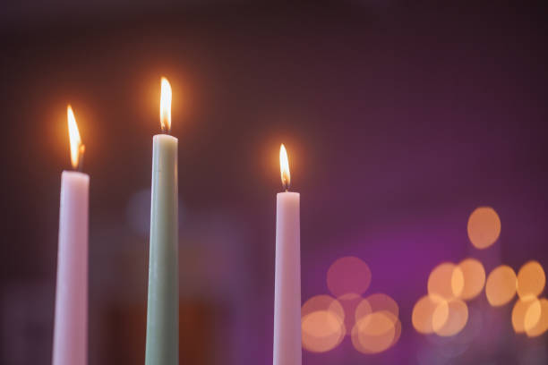 istock Three white candles with a purple background. 1743121396