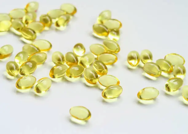 yellow vitamin capsules on a white background. food supplements, health care concept