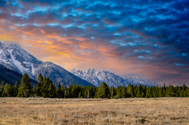 coucher de soleil au-dessus des pics majestic de la chaîne de teton du parc national de grand teton dans l’état américain du wyoming - wyoming teton range jackson hole autumn photos et images de collection