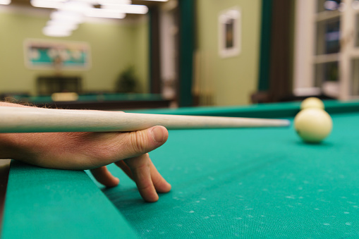 Pgotography of playing billiards. Billiard balls and cue on a green pool table. Billiard sports concept. Russian billiard game. Russian billiards, cue sport. Green baize. Close up image