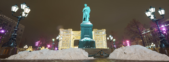 Moscow, Russia - February 12 2020: Photography of a bronze statue of russian poet Alexander Sergeyevich Pushkin in Moscow Pushkinskaya square. Literary heritage theme. Cold winter night