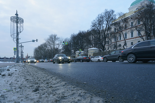 Moscow, Russia - February 19, 2021. Cityscape in winter. Kremlin Spasskaya Tower, Saint Basil's Cathedral (Cathedral of Vasily the Blessed). Motorway is filled out by cars. White and gray