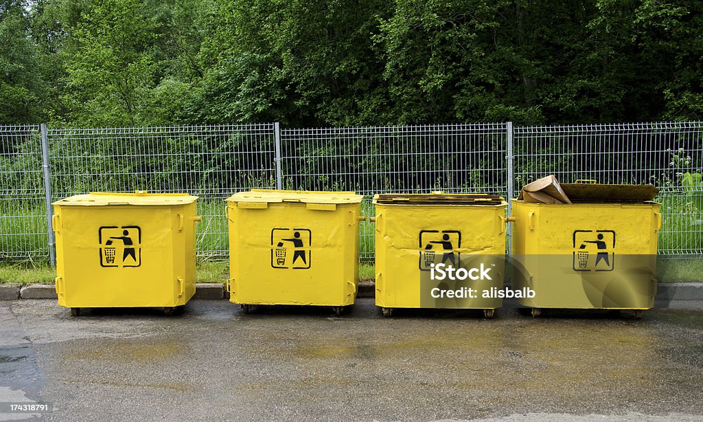 four old yellow trashcans four old yellow trashcans in parking place Color Image Stock Photo