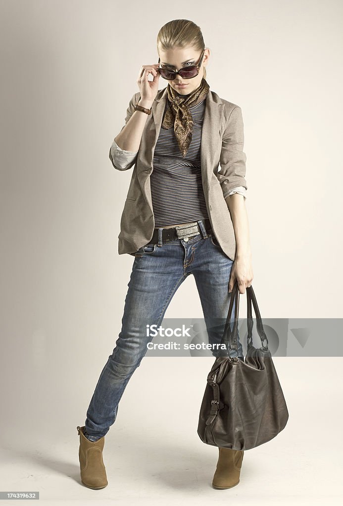 Fashion shopping model Fashionable shopping girl. Sexy blond Caucasian female in sunglasses holding leather bag. Adult Stock Photo