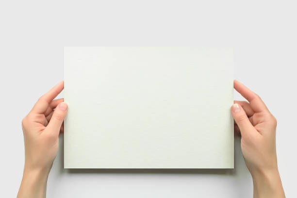 istock female hands hold empty a4 cardboard banner on white background. empty space for text 1743208641