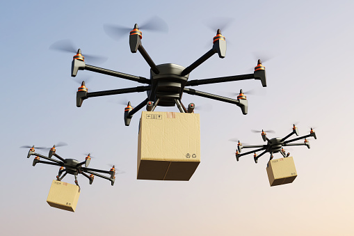 Heavy lift drones carrying a brown carton box parcel flying in the air. Illustration of the concept of drone delivery