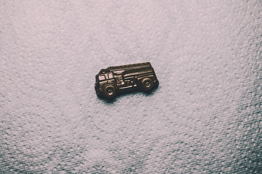 a miniature fire truck. copper reproduction of a fire truck. small copper truck isolated