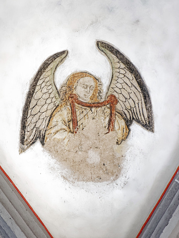 old fresco of an angel with harp, unfinished restored