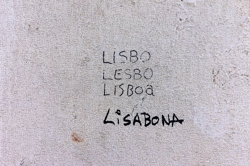 A photograph of 'Lisboa' written on a wall, showcasing the word in French, Portuguese, and other languages