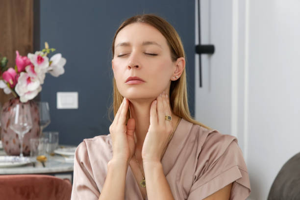 istock Caucasian woman touching her throat. Sore throat, cold, flu, tonsillitis or thyroid gland problem 1743283977