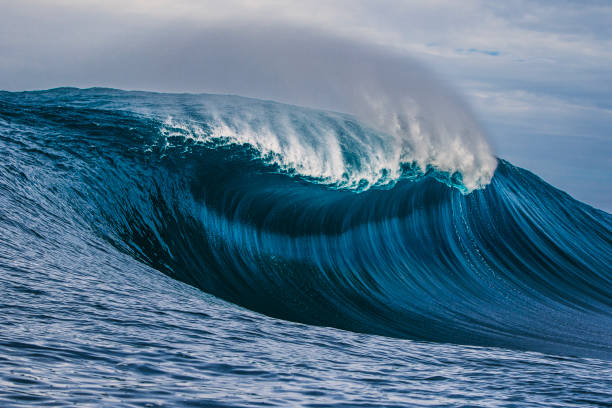 istock Big blue curved wave breaking in the open ocean over a shallow reef bombora 1743289279
