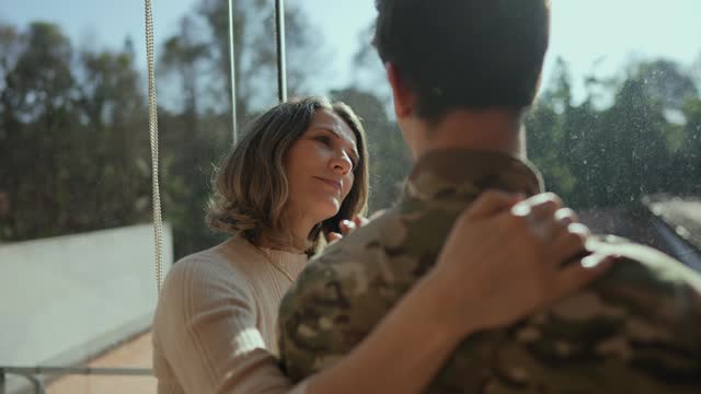 Mature woman talking with her soldier son at home