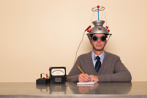 A retro dressed businessman conducts a scientific experiment to understand the inner workings of his brain.