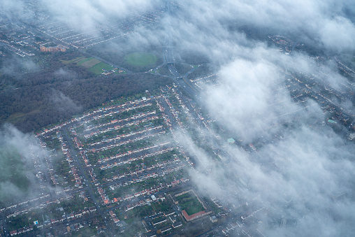 Aerial view of Suburban british victorian housing estate through the clouds