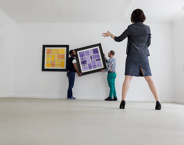 istock Female Gallery owner hanging a picture 174333073