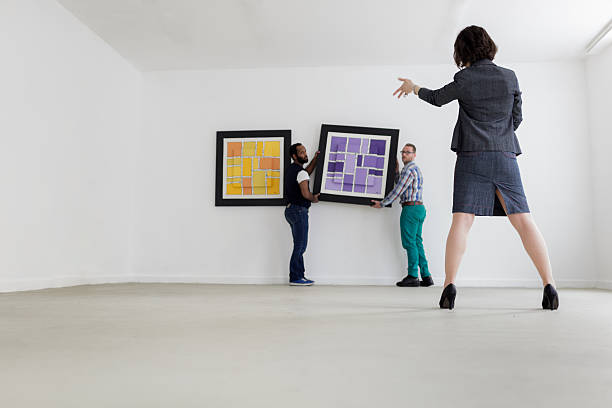 istock Female Gallery owner hanging a picture 174333074
