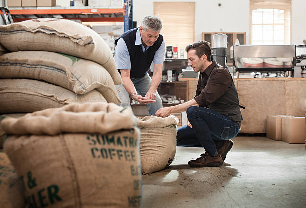 мужской владелец кофе roasting бизнес разговор с сотрудником - coffee bag стоковые фото и изображения