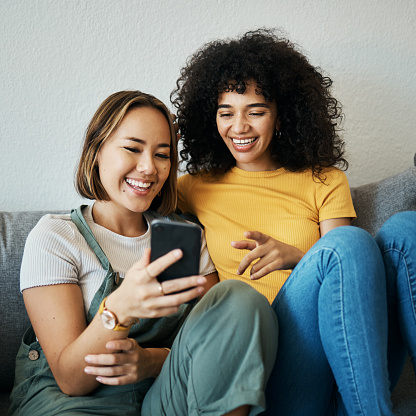 Women, relax on sofa with smartphone and chat online with communication, funny meme and reading text message. Friends with technology, mobile app and  typing on social media with connectivity at home