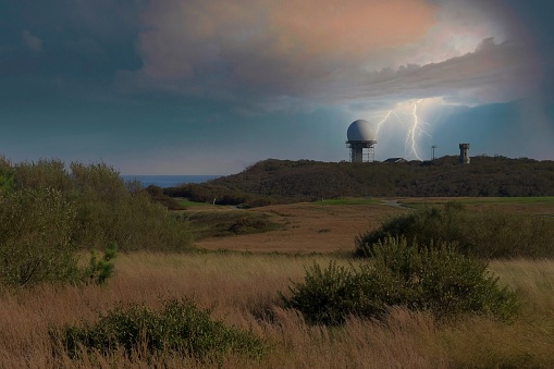 Digitally designed image of aircraft radar being struck by lightning. The ARSR-4 radar installation at North Truro, Cape Cod with ominous storm clouds and lightning.