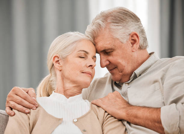 istock Old people, hug and forehead touch, relax on sofa with love and support, bonding while at home with trust and comfort. Couple together in marriage, partner and retirement with calm and peace of mind 1743350948