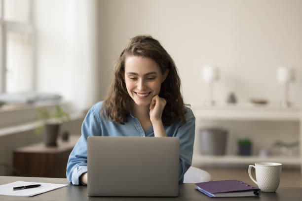 istock Positive young freelancer girl working at laptop, typing 1743358758