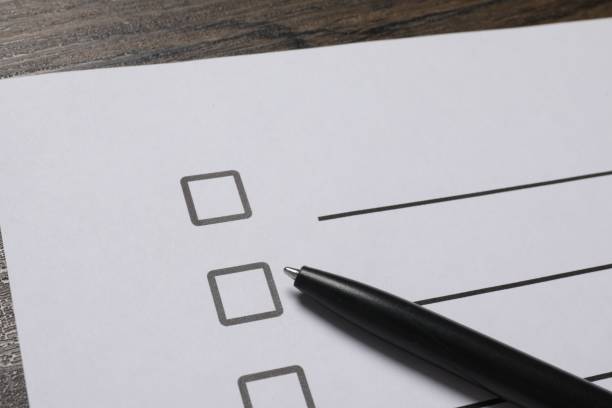 istock Paper sheet with checkboxes and pen on wooden table, closeup. Checklist 1743363626