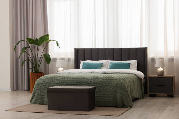 istock Comfortable bed, bedside table and ottoman in bedroom 1743364710