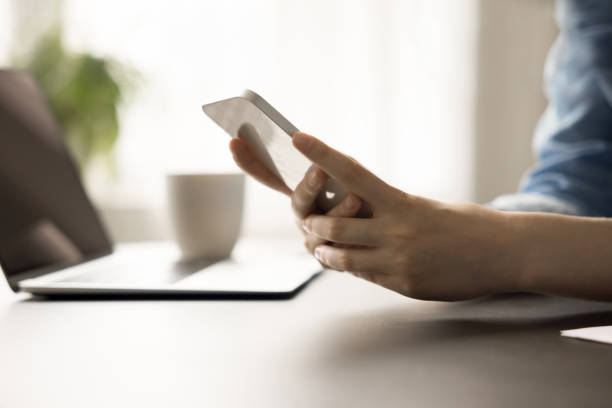 istock White mobile phone in female hands over workplace table 1743365842