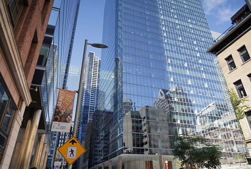 Toronto, Canada - August 27, 2023: Low angle view from Temperance Street of the reflective towers at the Bay Adelaide Centre between Yonge Street and Bay Street . Summer morning with blue skies over the downtown Financial District.