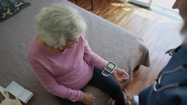 Nurse taking pressure of a senior woman at home